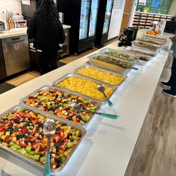 A long buffet line of breakfast food, including fruit salad and scrambled eggs, at Mikayla's Cafe.